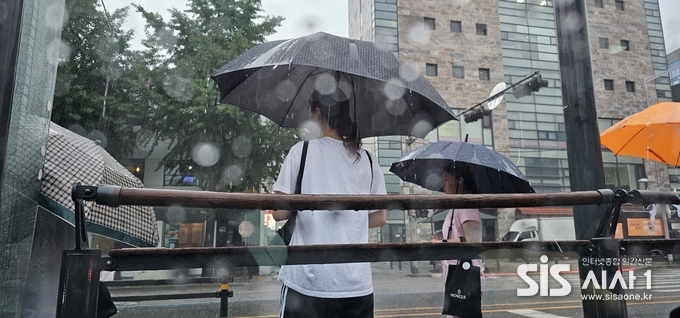 17일 아침 출근길에 폭우가 쏟아지는 가운데 서울 서대문구 홍재동 버스정류장에서 시민들이 우산을 쓰고 버스를 기다리고 있다.(사진=윤여진 기자)2024.6.17 시사1