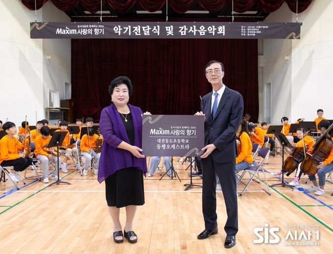 .31일 대전 대덕구 대전동도초등학교에서 열린 ‘제17회 맥심 사랑의 향기’ 행사에서 동서식품 최상인 홍보상무(오른쪽)와 대전동도초등학교 강창숙 교장이 기념촬영을 하고 있다. (자료 = 동서식품)